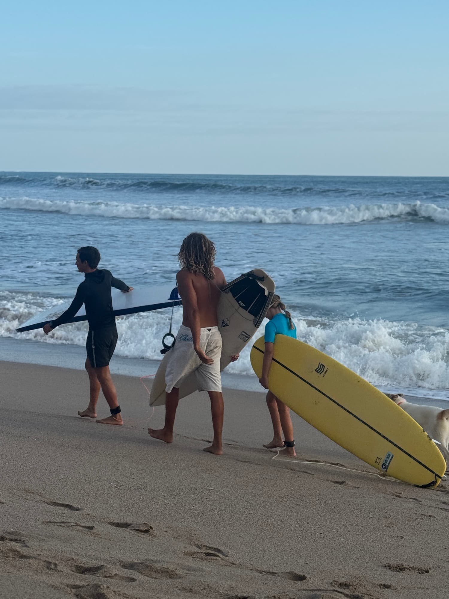 Coach and student carrying boards to the water at Guiones